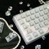 Translucent PC keycaps for a mechanical keyboard displayed on a dark surface with scattered crystals.