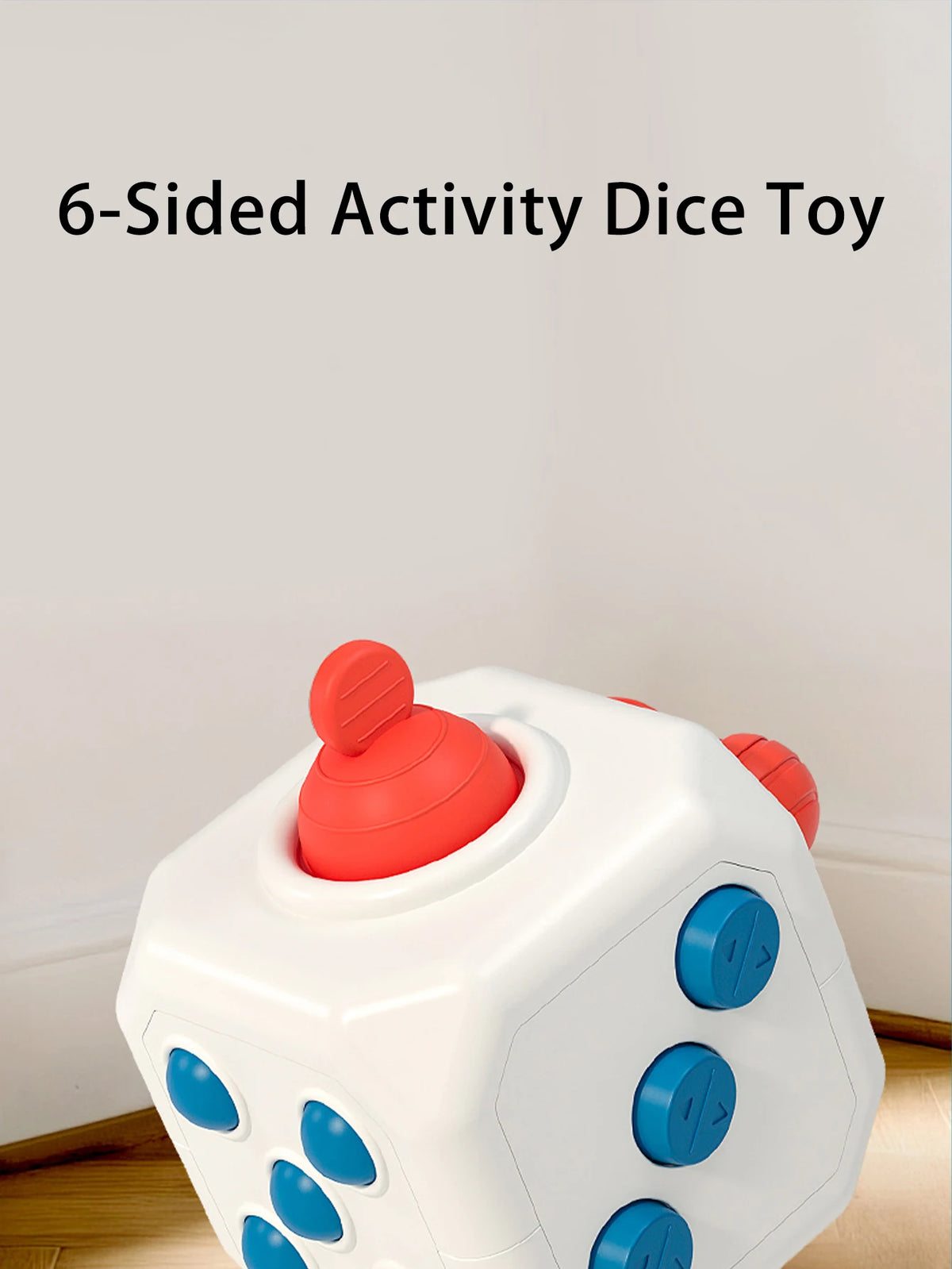 A white, six-sided activity dice toy with red and blue accents is shown on a wooden surface.