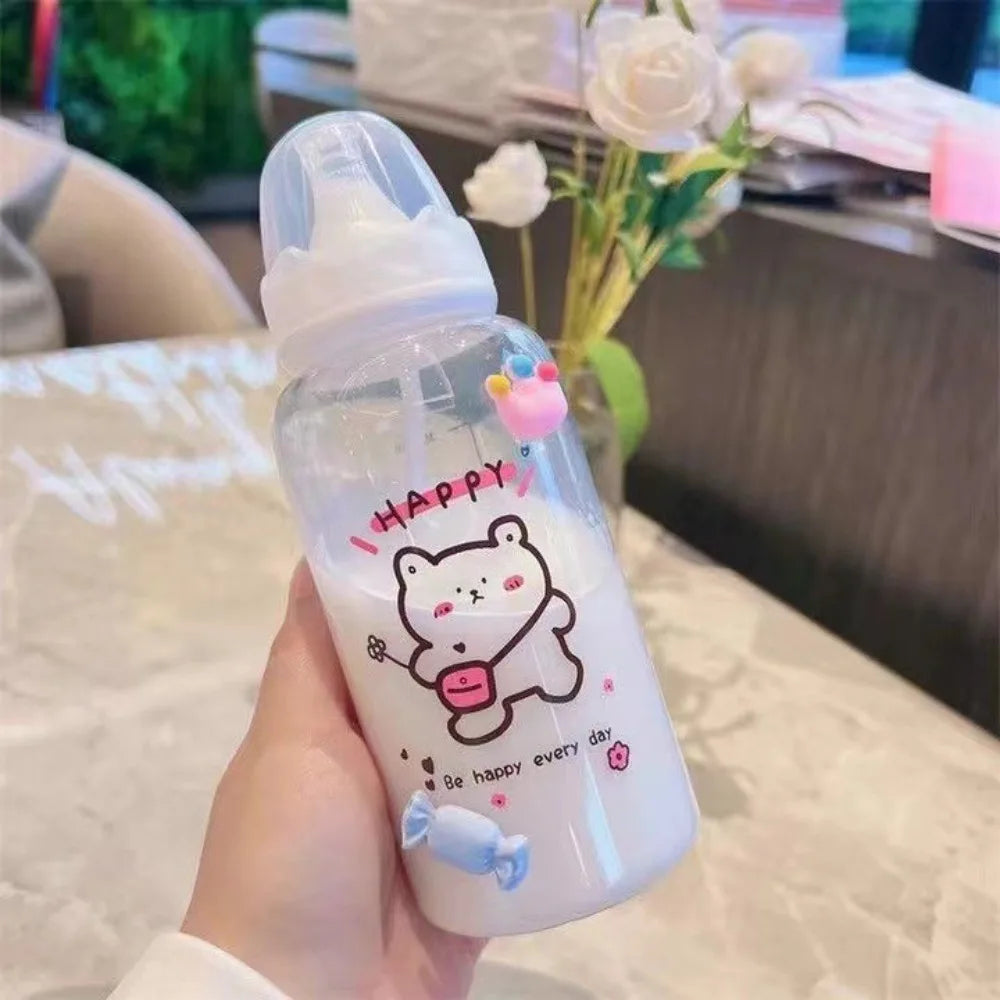 A hand holds a clear water bottle with a cute pink bear design and text on it.