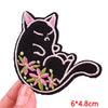Black cat embroidery patch with pink floral accents on a beige background