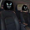 A pair of black car headrest covers featuring a creepy, snarling monster face design.