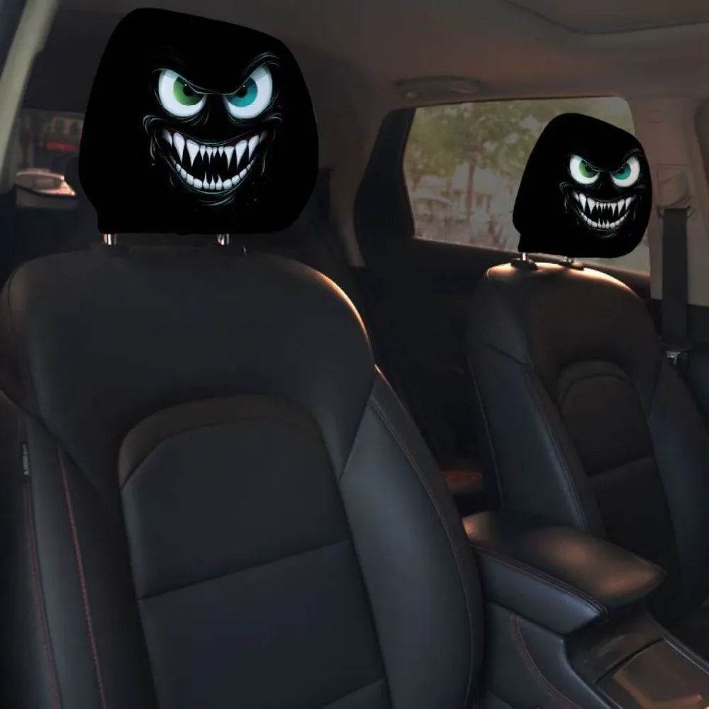 A pair of black car headrest covers featuring a creepy, snarling monster face design.