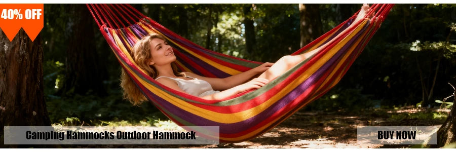 A woman relaxing in a colorful outdoor hammock in a wooded setting.