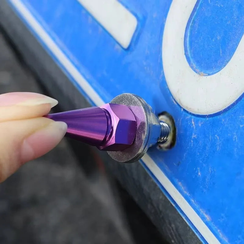 A hand holds a purple M6 license plate bolt with a silver threaded end against a blue and white surface.