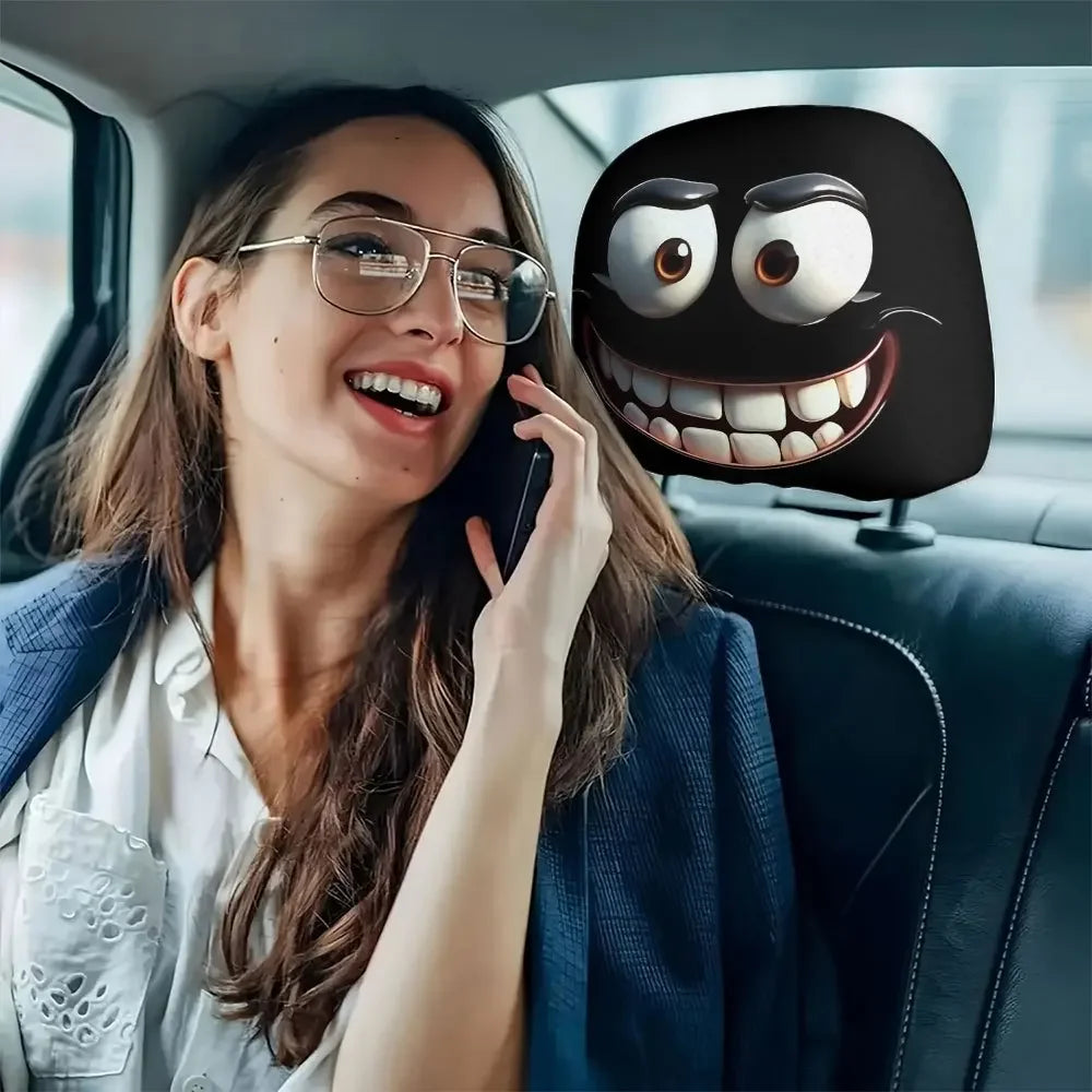 A woman smiling while using a phone in a car, with a black smiley face headrest cushion cover visible.