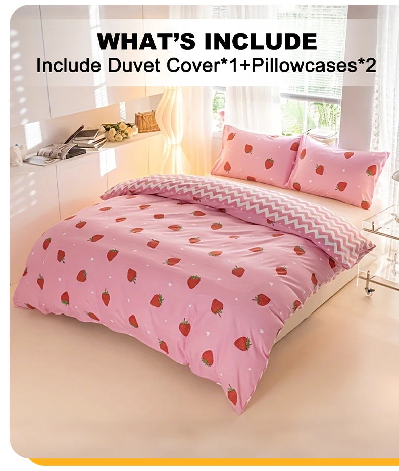 A pink strawberry print duvet cover set with two pillowcases displayed on a bed in a bright room.