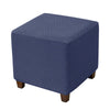 A dark blue stretch jacquard ottoman slipcover with an elastic edge.