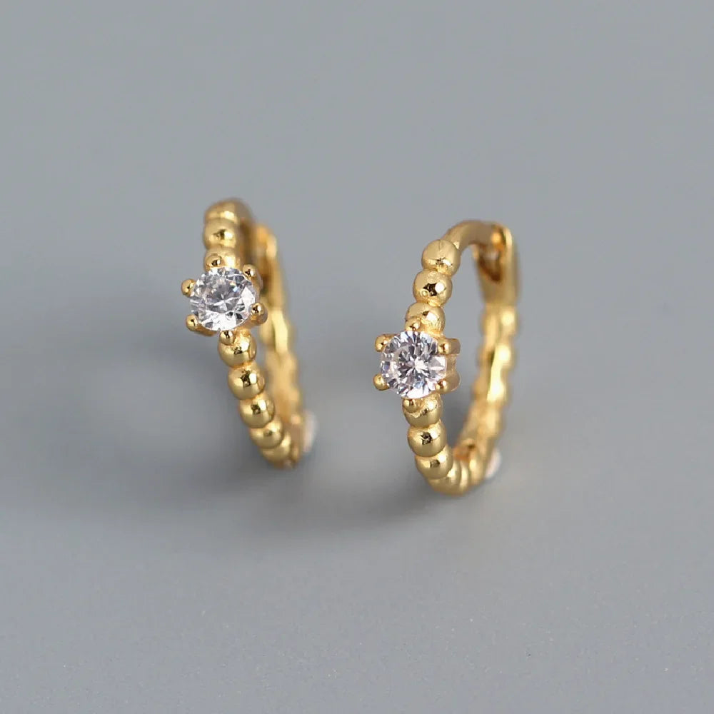 Pendientes de aro dorados con piedras de circonita cúbica redonda.