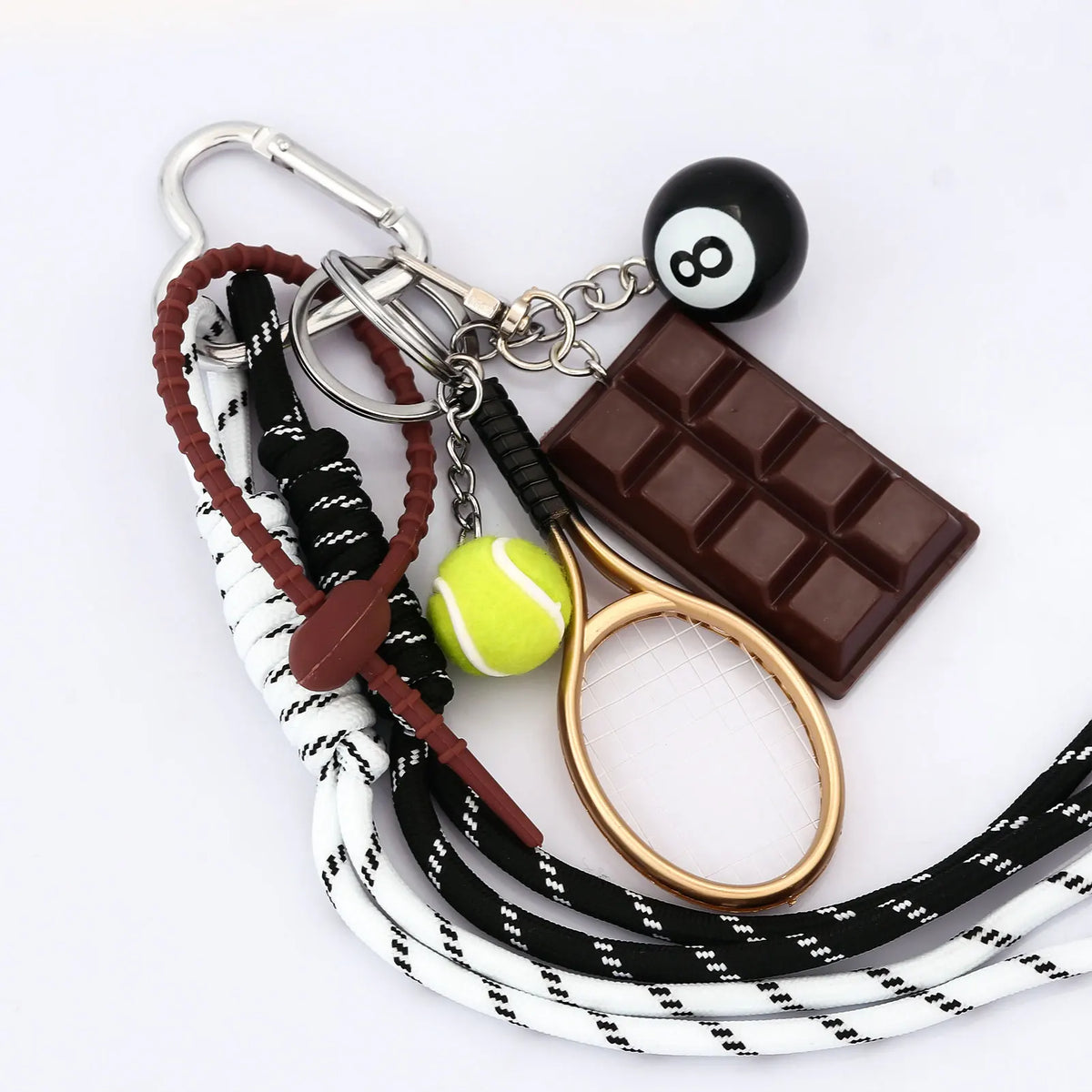A metal 8-ball keychain featuring a black finish, attached to a leather strap and a chocolate bar.