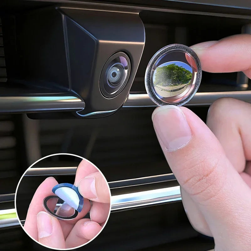 A hand is holding a clear lens protector for a car camera, showing a view of greenery.