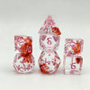 A set of seven polyhedral gaming dice in pink and orange translucent plastic, including a pyramid shape.