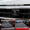 A close-up view of a car camera lens protector installed on a vehicle grille, demonstrating clear image protection.