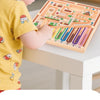 A child is using a magnetic maze logic puzzle board for early learning, featuring colorful wooden pieces and tracks.