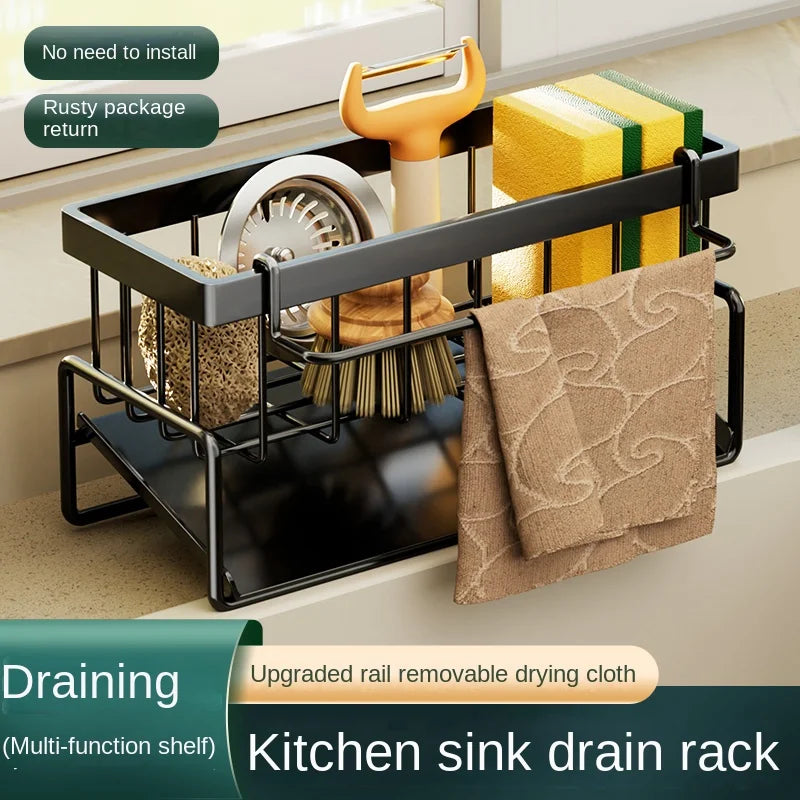A black kitchen sink drain rack with a stainless steel tray holding a folded cloth and other items.