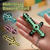 A hand holds a multi-shape diamond sword keychain made of glow-in-the-dark plastic pieces.