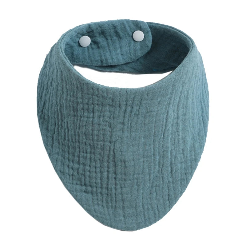 A soft, teal organic cotton muslin baby bib with an absorbent band around the neck.