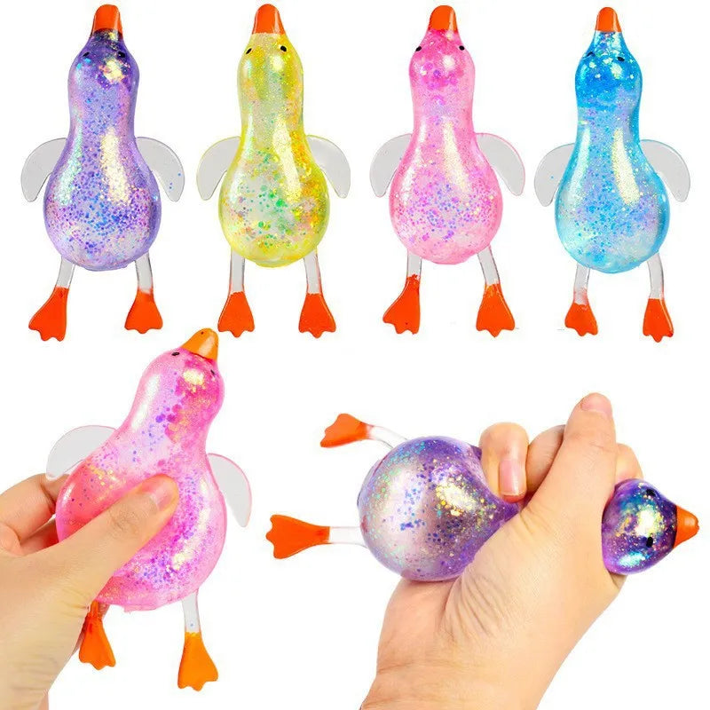 Eine Hand presst ein rosa Glitzer-Enten-Stressballspielzeug, das verschiedene Farben zeigt.