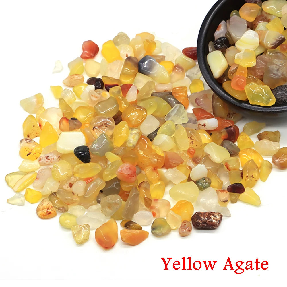 Yellow agate tumbled crystal stone chips scattered on a white background.