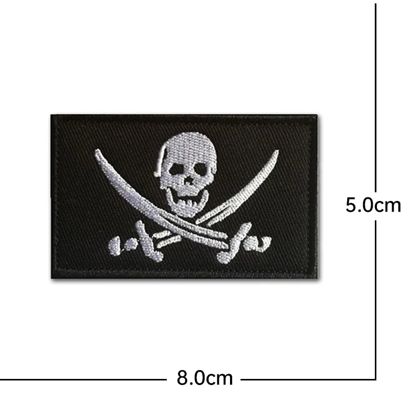 Black embroidered patch featuring a skull and crossed swords design with silver threads.
