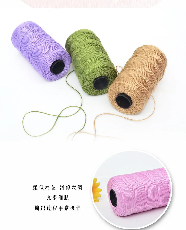 Three spools of purple, green, and tan polyester knitting yarn with loose strands.