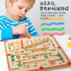 A child is interacting with a wooden magnetic color sorting maze board for educational play.