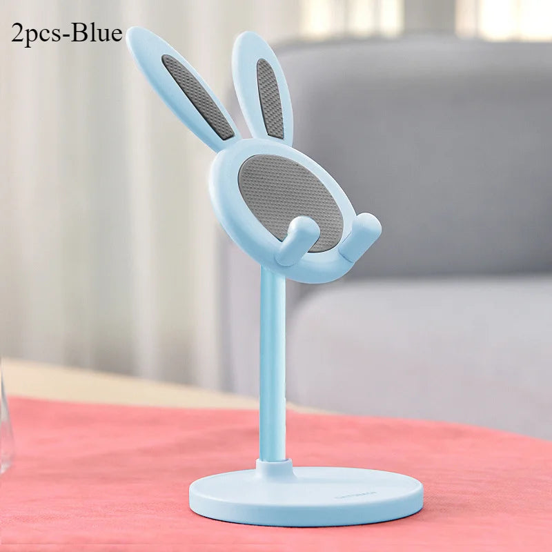 A light blue rabbit-shaped mobile phone and tablet stand with a mesh design, shown on a pink surface.