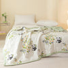 White quilt featuring a floral pattern with small panda motifs on a light green border.