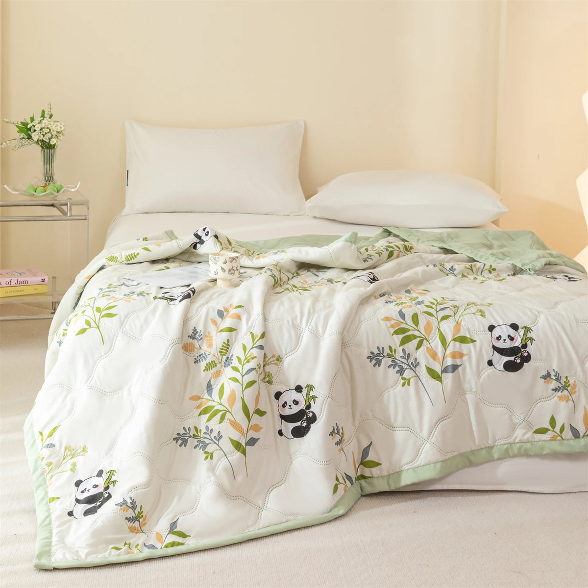 White quilt featuring a floral pattern with small panda motifs on a light green border.