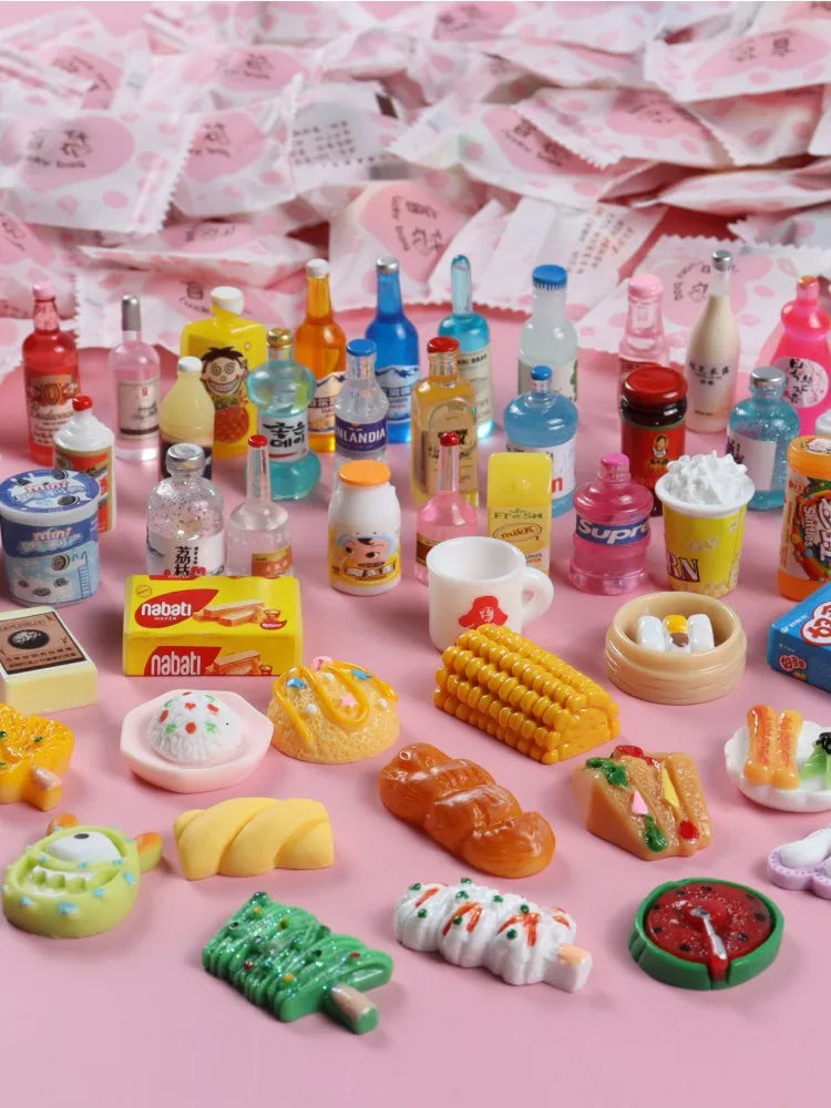 A collection of miniature resin food and drink figurines in various colors and shapes displayed on a pink background.