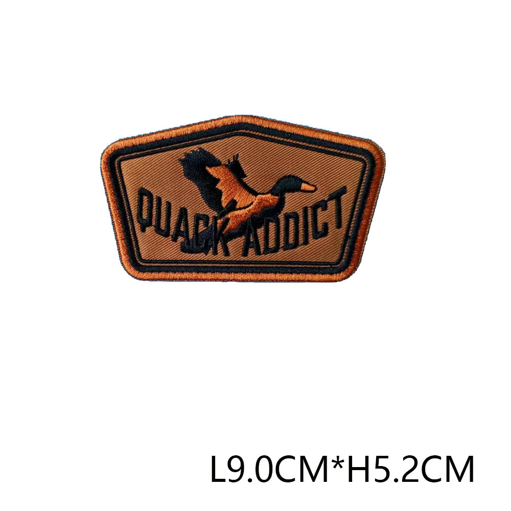 An embroidered hunting patch badge with the text QUACK ADDICT on an orange background.