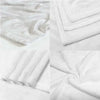 White flannel throw blanket folded and draped on a white surface.