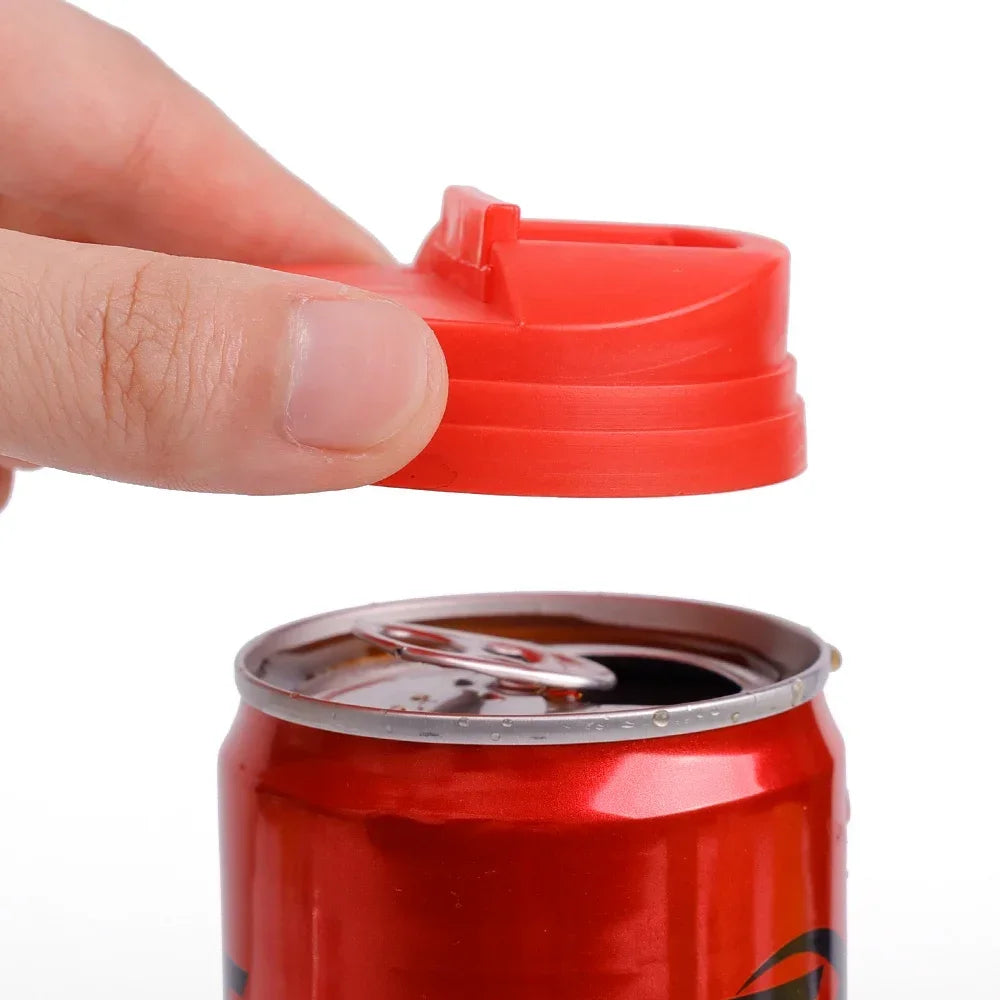 A hand is holding a red reusable leakproof can cover, positioned above a red soda can.