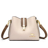 A light beige leather shoulder bag with gold hardware and a brown strap.
