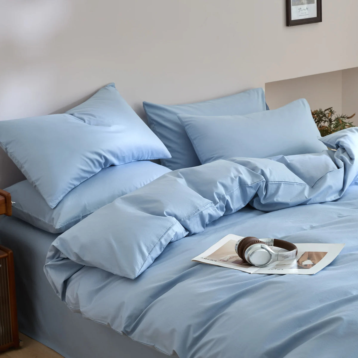 Light blue quilted duvet cover set with matching pillowcases on a bed.
