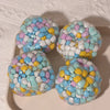Four colorful squishy stress balls with pastel blue, pink, and white confetti.
