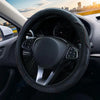 Interior view of a car showing a black steering wheel with leather grip and stitching.