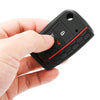 A hand holds a black silicone car key fob cover with a red accent, showing the protective case design.