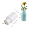 A white silicone mold with a removable base and a light blue glass vase containing a yellow flower.