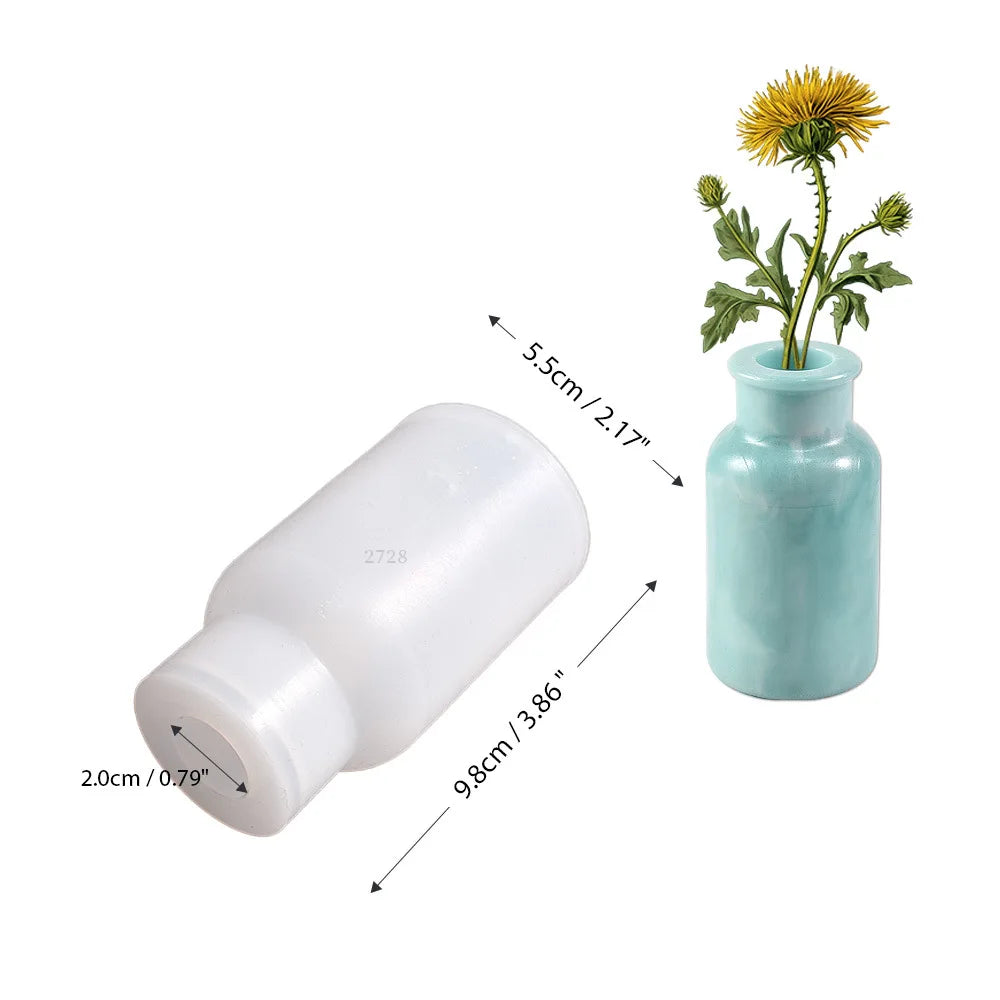 A white silicone mold with a removable base and a light blue glass vase containing a yellow flower.