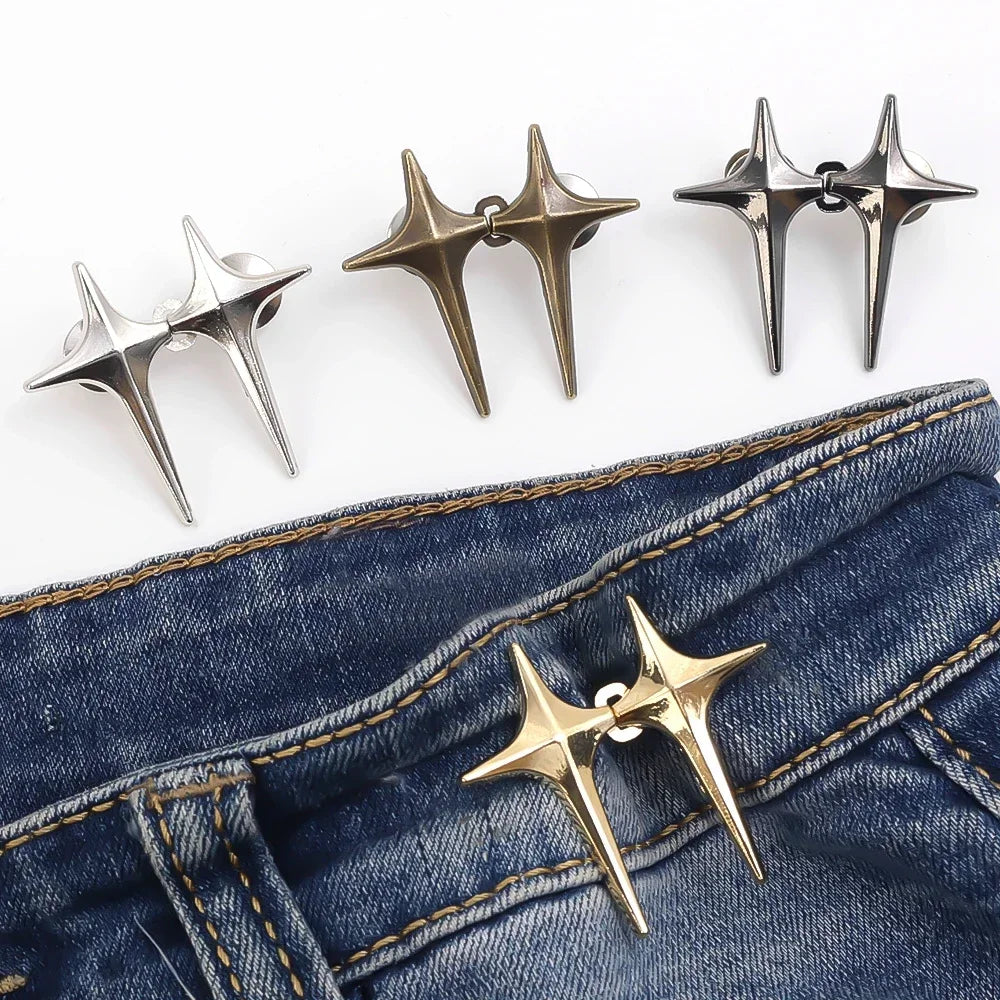 A set of gold-toned Y2K star waist tightener clips for jeans displayed against a dark denim background.