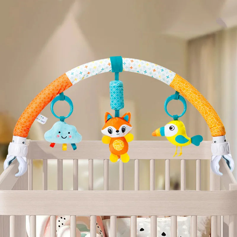 A baby stroller arch toy featuring an orange and white curved bar with hanging plush charms including a cloud, a fox, and a y