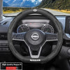 Interior view of a Nissan steering wheel with carbon fiber trim and sport design.