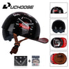 Black retro open face motorcycle helmet with a leather strap and an orange and red graphic