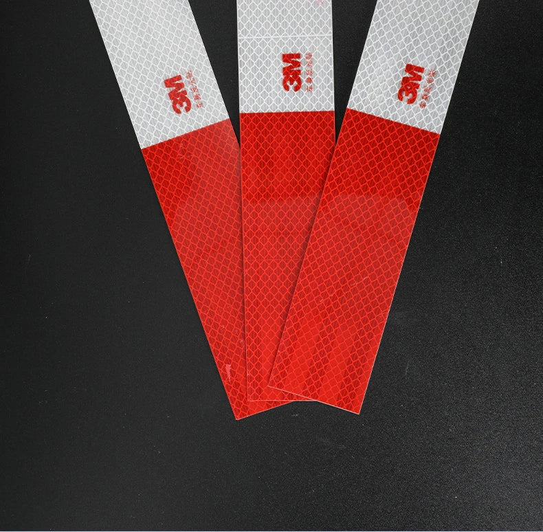 Three strips of red and white reflective decals are displayed against a black background.