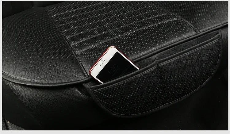A black car seat cover shows a smartphone resting on the leather surface.