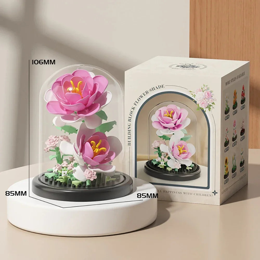 A pink and white eternal rose bouquet micro building block set displayed on a white stand.