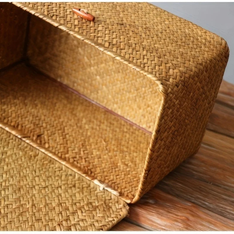 A close-up view of a woven rattan storage basket with a lid resting on a wooden surface.