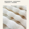 Close-up of a soft, cream-colored bubble fleece throw blanket with a fluffy texture.