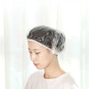 A woman is shown wearing a disposable shower cap while looking down, emphasizing its light and convenient use.