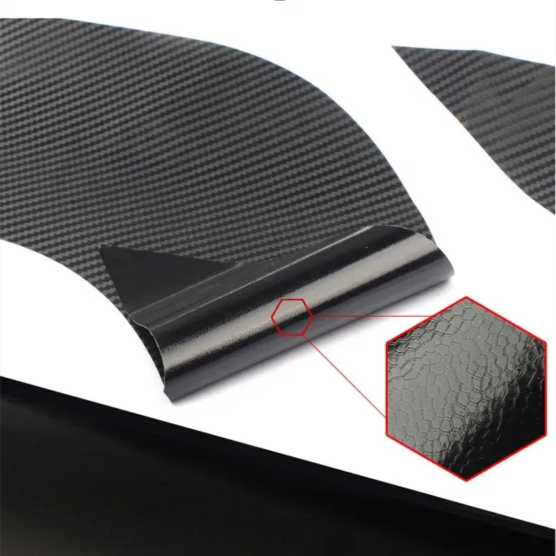 A close-up view of a black carbon fiber door handle protector film applied to a car door surface.